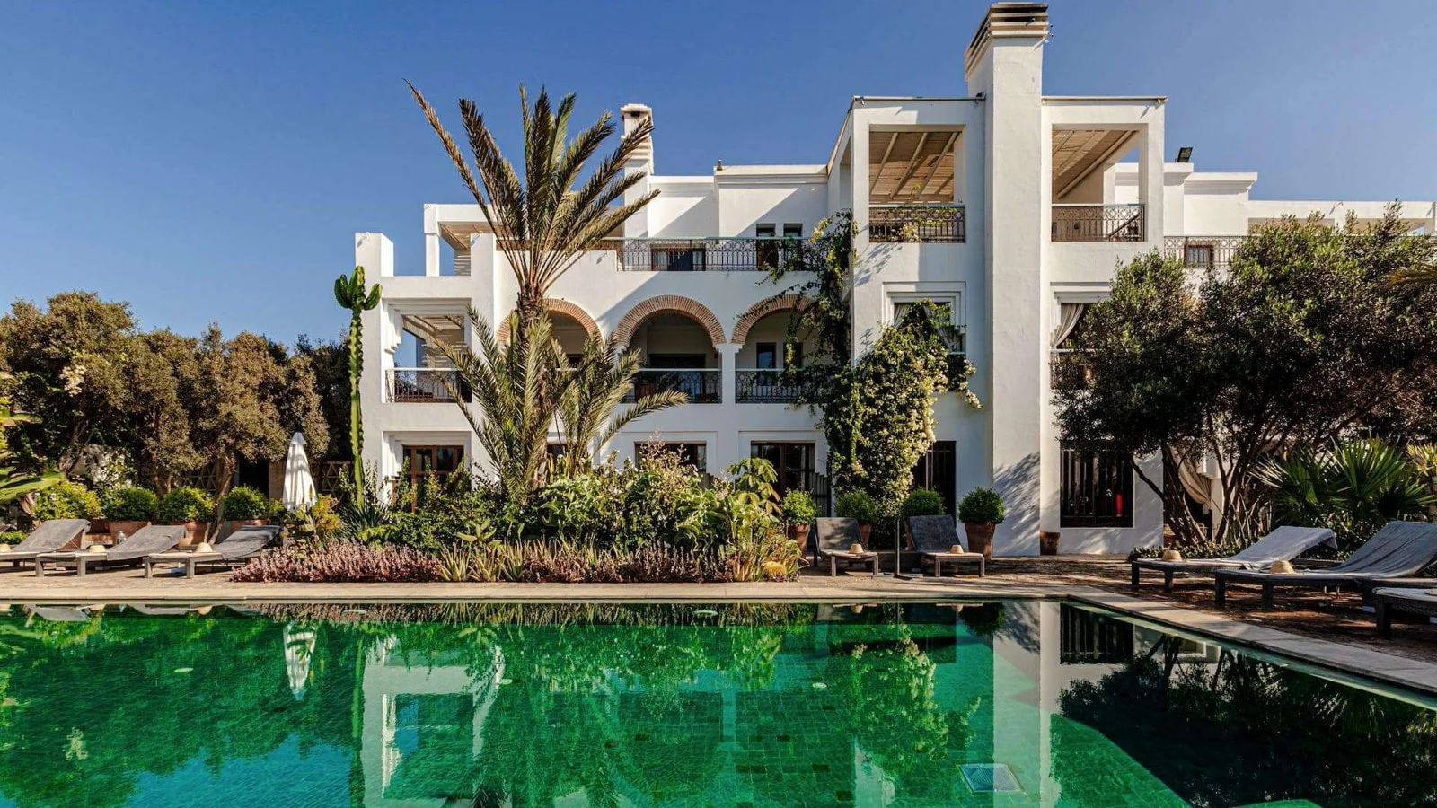 Swimming pool and hotel exterior at Riad Villa Blanche