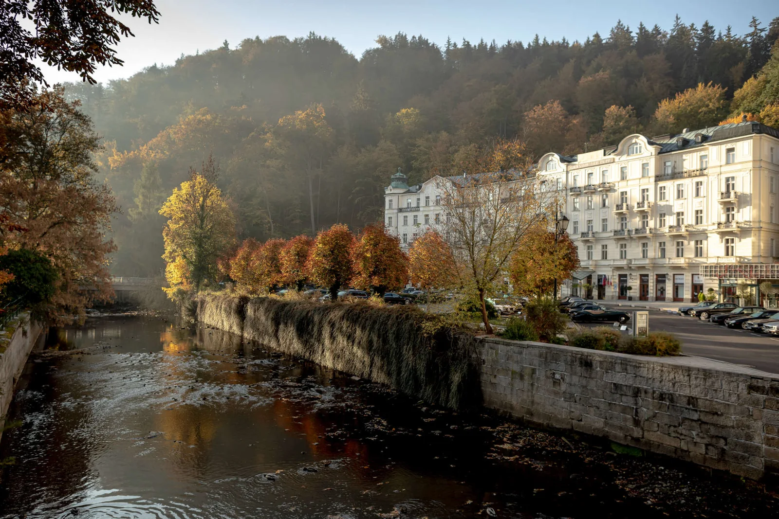 Grandhotel Pupp beside the river in autumn