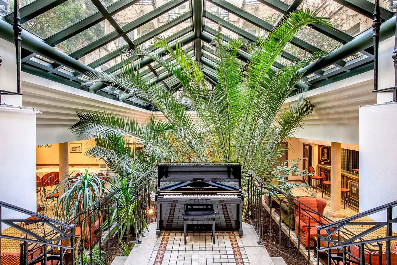 The glass-roofed winter garden and piano at Villa Beaumarchais in Paris