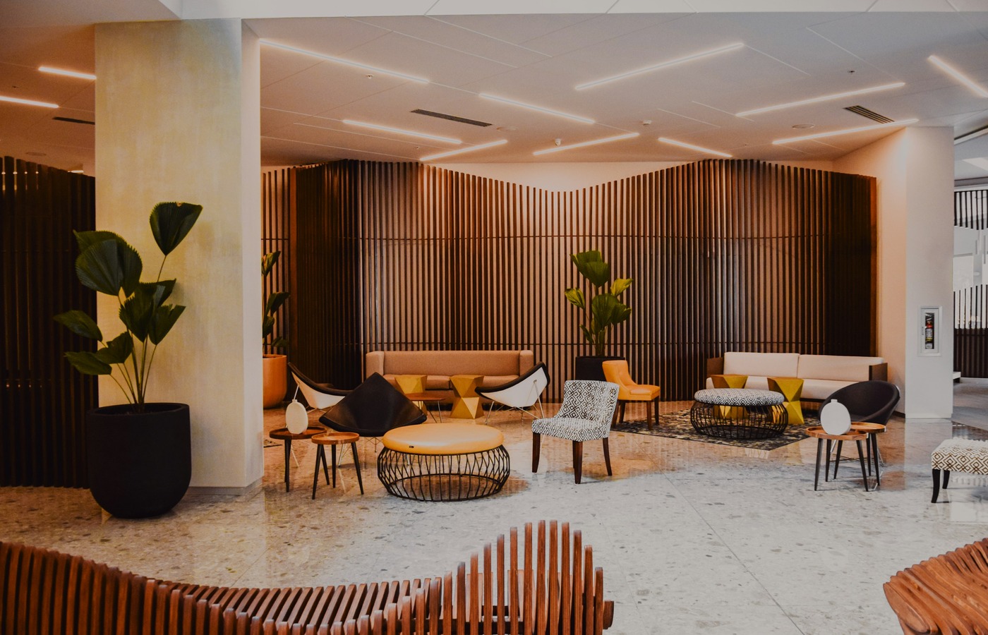Hotel lobby with seating areas, wood walls and a reception desk