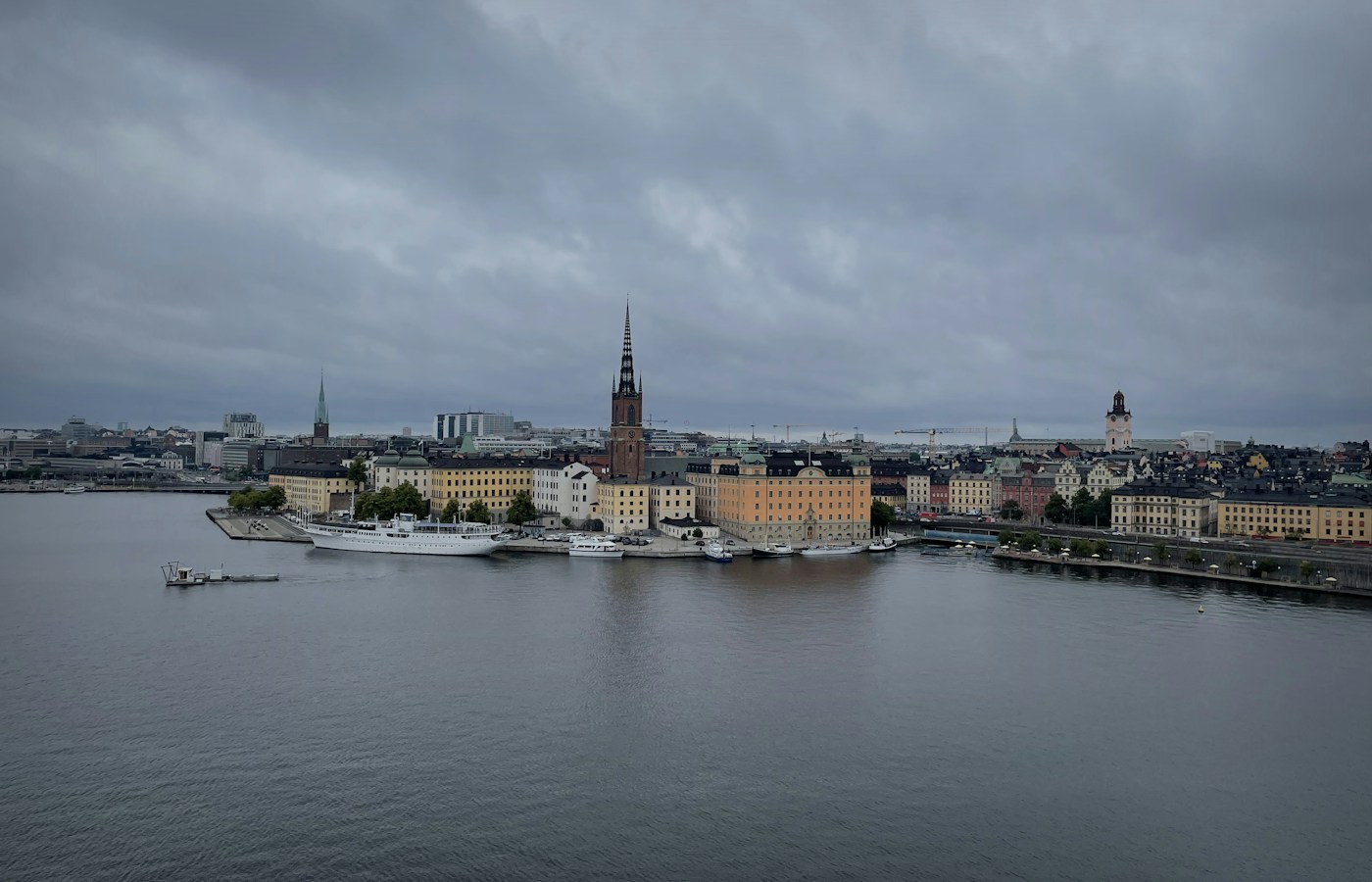 Stockholm waterfront buildings and church spires beneath a cloudy sky