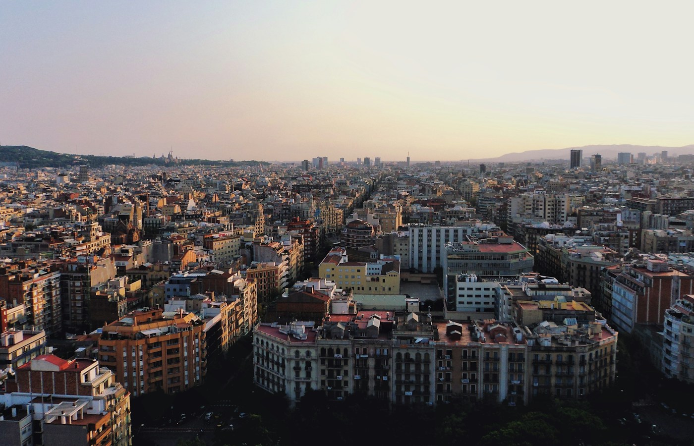 Aerial view across Barcelona’s Eixample blocks in warm evening light
