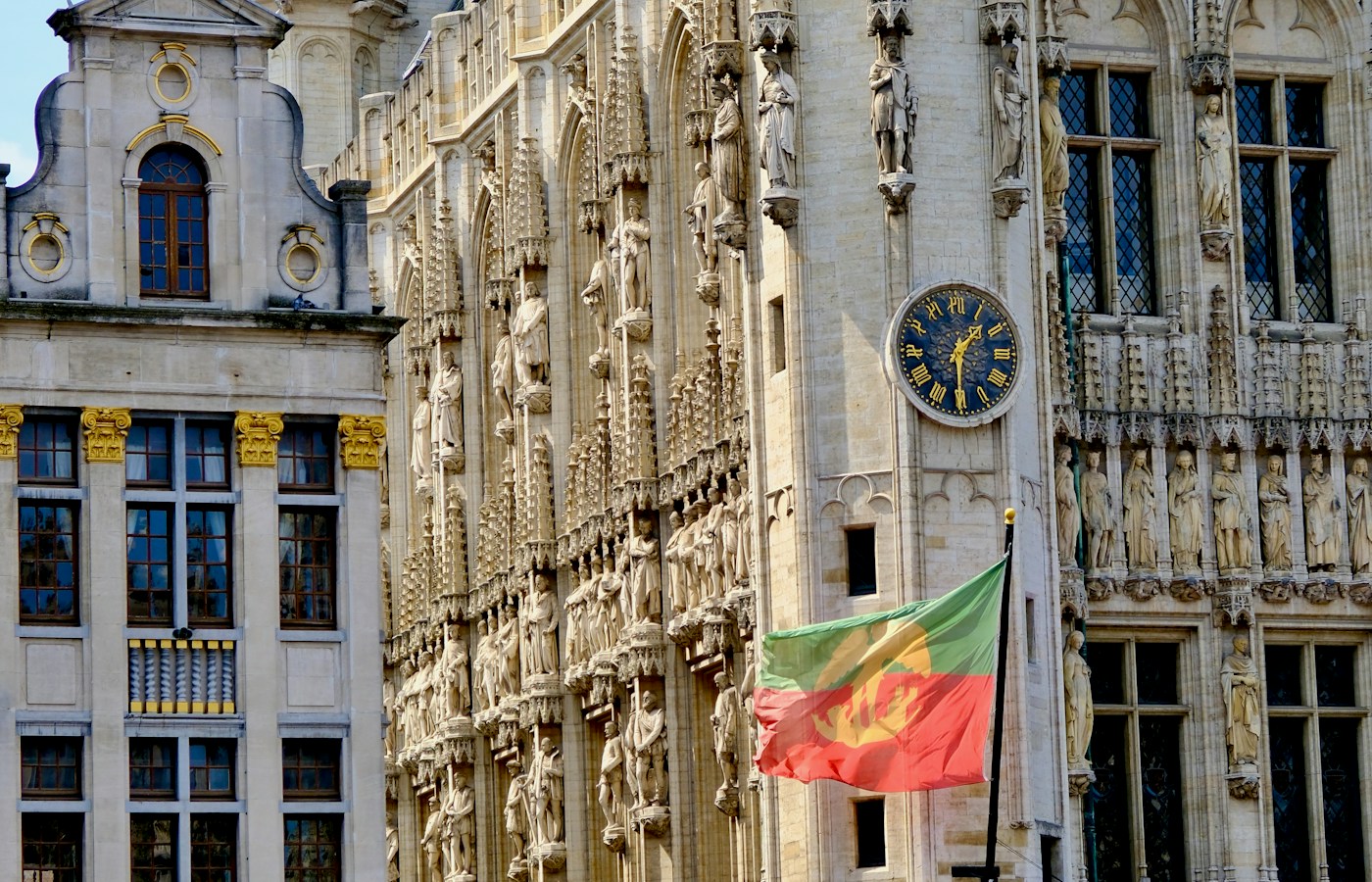 Sculpted stone façades, a clock and a flag at Grand-Place in Brussels