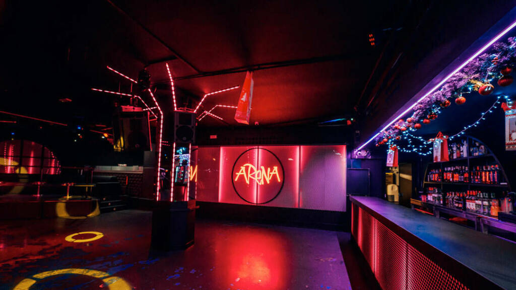 Interior of Arena Experience with red and purple lighting and the Arena sign