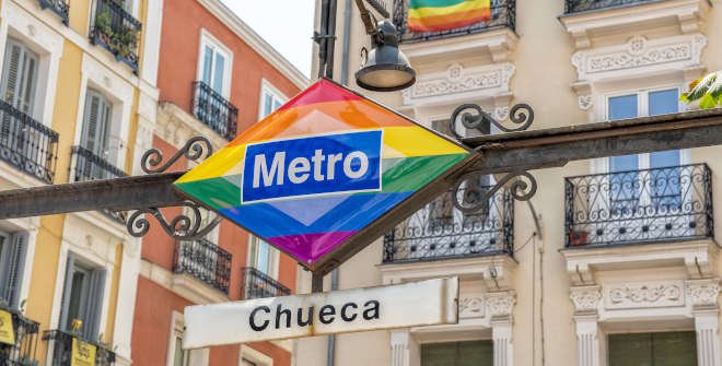 Rainbow-coloured Chueca metro sign against the buildings around the square