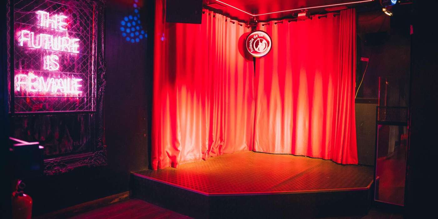 Red-curtained stage and The Future Is Female neon sign at Fulanita de Tal