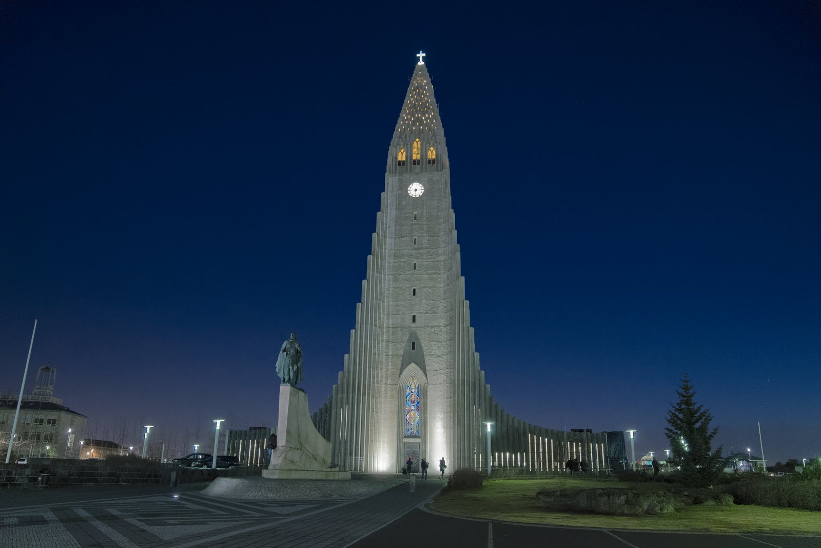 Hallgrímskirkja illuminated at dusk with the Leif Erikson statue in front