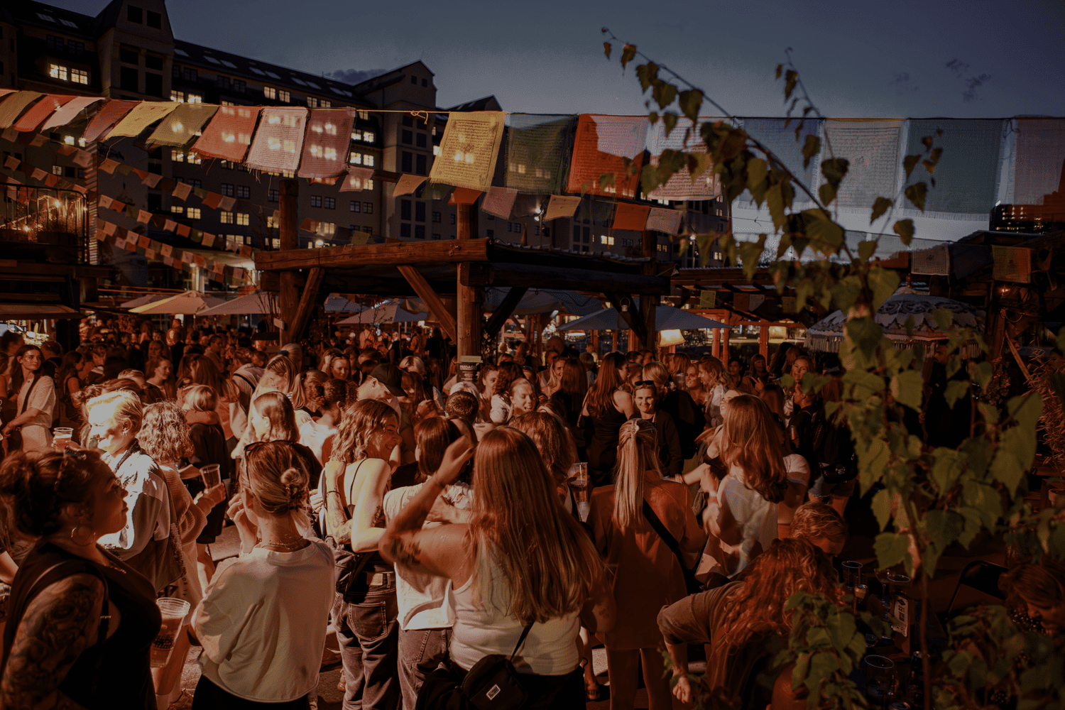 Guests gathered outdoors at SALT beneath bunting beside Oslo’s waterfront