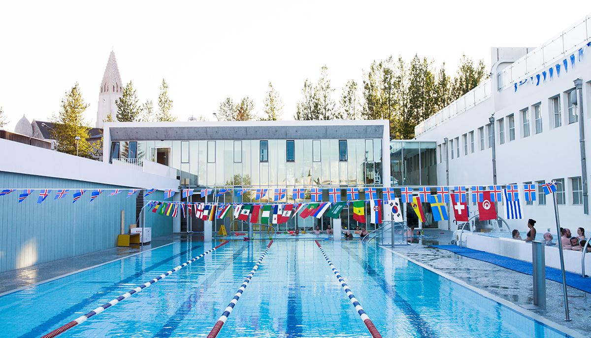 Sundhöllin’s outdoor swimming pool and hot tubs beneath strings of flags